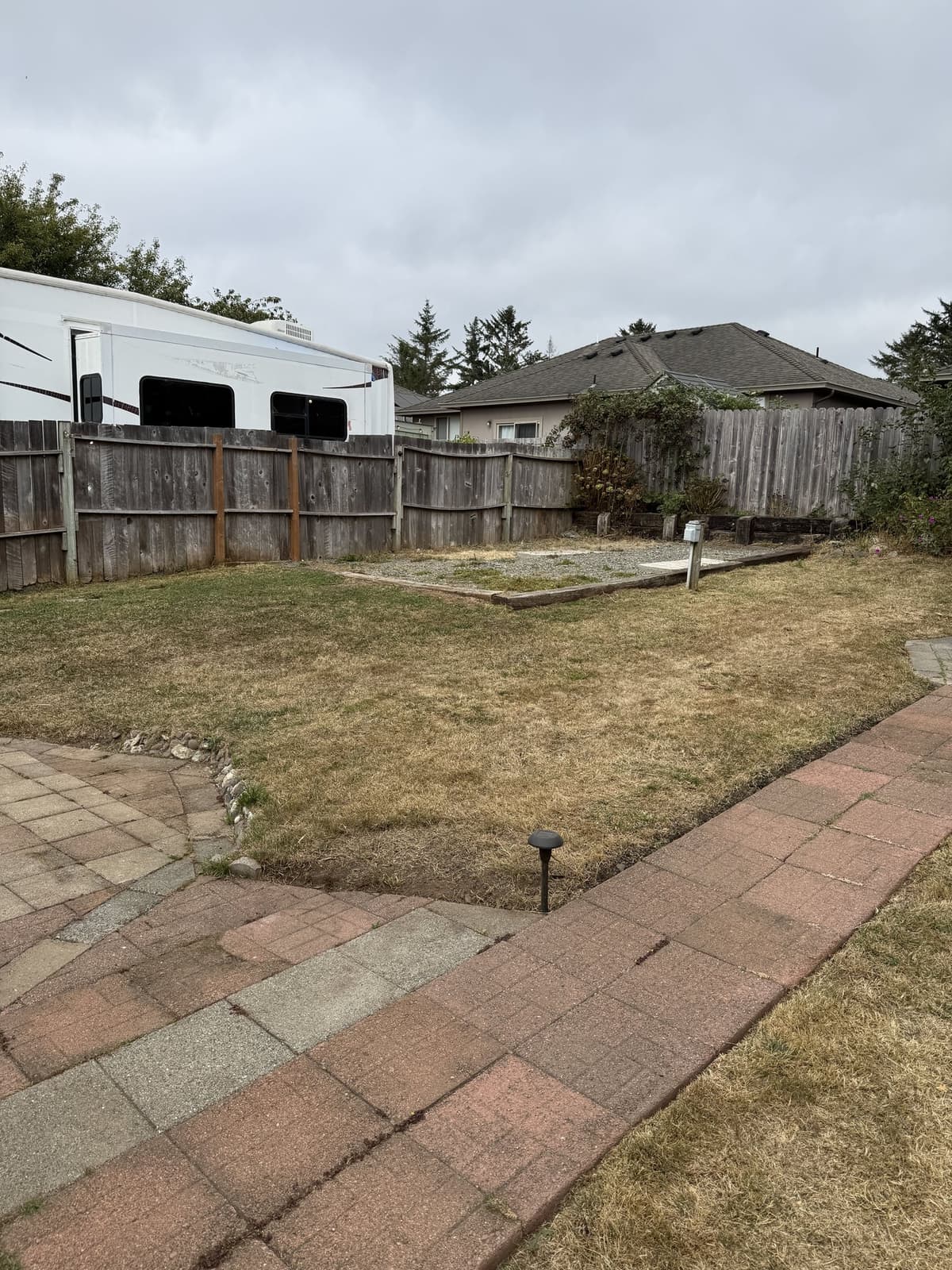 Mowed backyard lawn beside brick garden paths