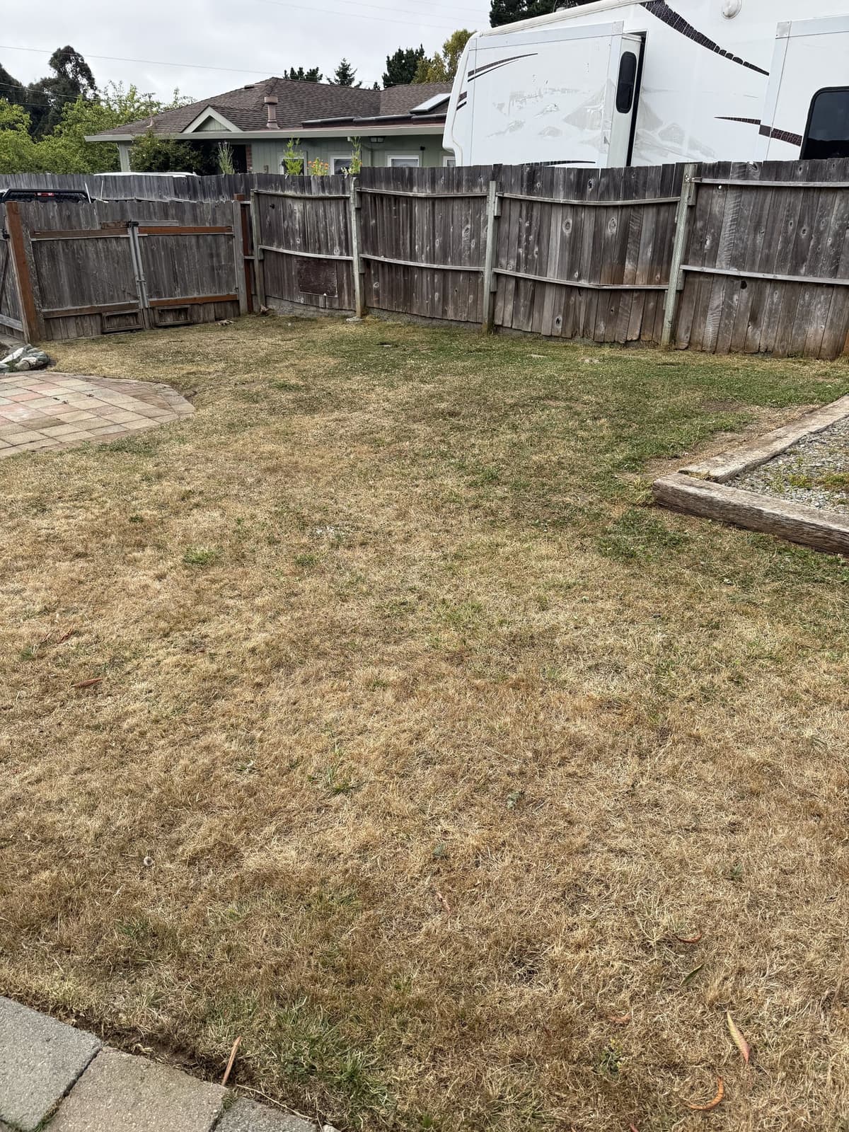 Trimmed lawn along a wooden fence and raised garden border